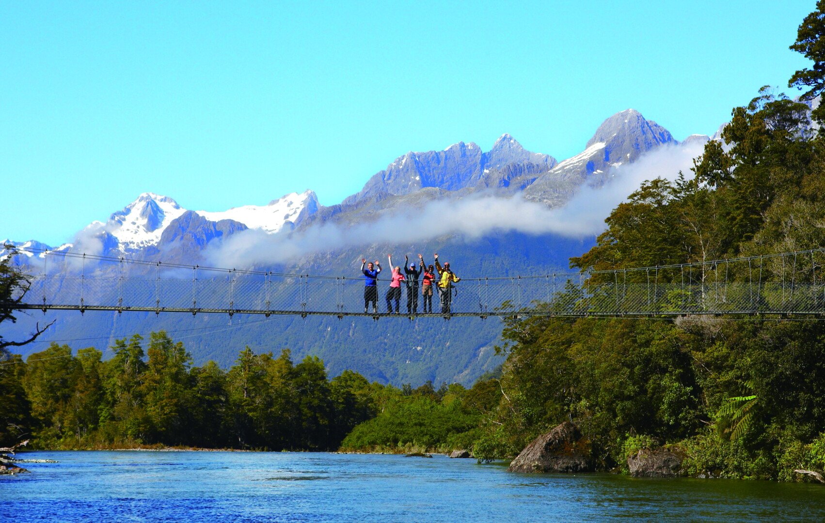 Happy hikers on Fiordland's longest swing bridge. 