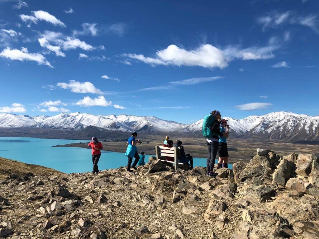 The glacial-fed turquoise waters of Lake Tekapo behind our group.