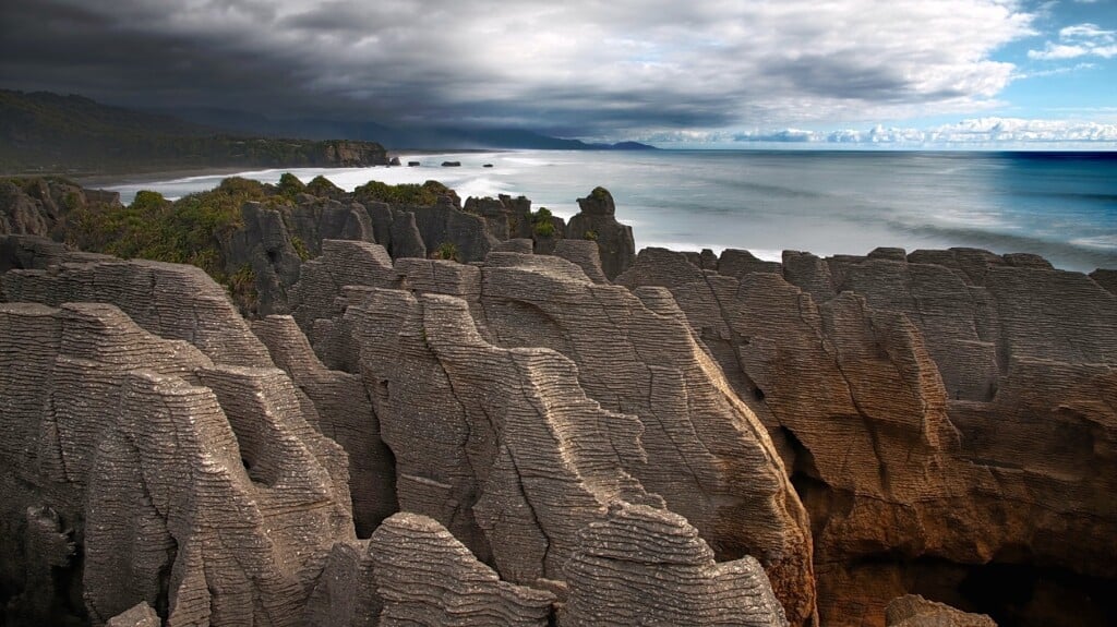 Walk the paths across the gantries and high limestone arches to view blowholes at Pancake Rocks, Punakaiki,